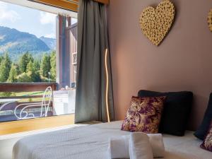 ein Schlafzimmer mit einem Bett und einem großen Fenster in der Unterkunft Studio Rosablanche D13 by Interhome in Siviez + 14 Fotos