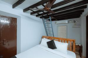 a bedroom with a bed with a ceiling fan at Harsha's Shambhavi River View Homestay in Mūlki