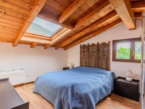 - une chambre avec un lit bleu et des plafonds en bois dans l'établissement Apartment Borgo Castello-1 by Interhome, à Argegno