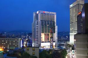 ソウルにあるホテル スカイパーク キングスタウン トンデムンの市の看板が貼られた高層ビル