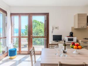 - une cuisine et un salon avec une table et des verres à vin dans l'établissement Apartment Borgo Castello-1 by Interhome, à Argegno