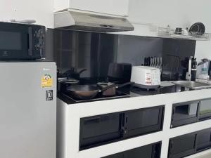 eine Küche mit Herd und Kühlschrank in der Unterkunft The Green Valley Escape in Ban Ko Khwan