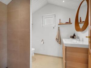 a bathroom with a sink and a toilet and a mirror at Holiday Home Adisl - 350m from the sea by Interhome in Torsted