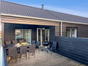 una terraza con sillas y una parrilla en una casa en Holiday Home Øthbiorn - 1-1km from the sea by Interhome, en Løkken