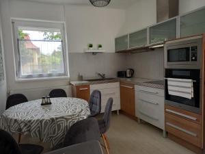 a kitchen with a table and chairs and a kitchen with a table and a window at Origo II in Debrecen