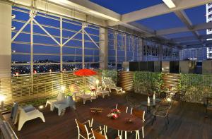 a large building with a patio with tables and chairs at Hotel Skypark Kingstown Dongdaemun in Seoul