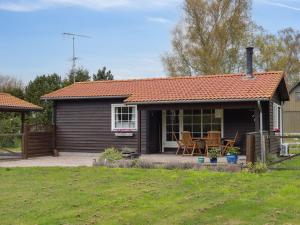 a small house with a table and chairs in a yard at Holiday Home Undis - 660m from the sea by Interhome in Gedser