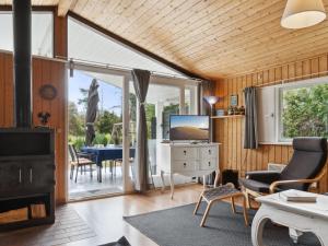 a living room with a fireplace and a tv and a table at Holiday Home Zoya - 470m from the sea by Interhome in Gedser