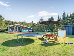 a picnic table and an umbrella in a yard at Holiday Home Zoya - 470m from the sea by Interhome in Gedser