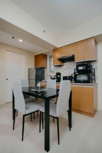 a kitchen with a black table and white chairs at NEW Comfy 1BR Cebu IT Park Location in Cebu City