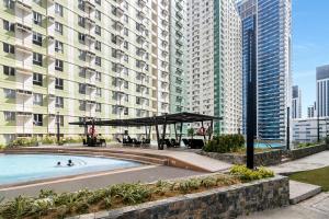 a swimming pool in front of a large building at NEW Comfy 1BR Cebu IT Park Location in Cebu City