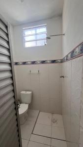 a bathroom with a toilet and a window at Casa inteira próx ao Hangar COP30 - 3km in Belém