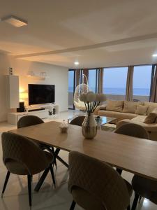 Una sala de estar con una mesa y sillas y un sofá. en Nice Duplex, en Praia