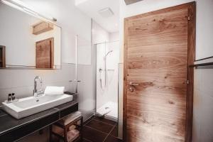 a bathroom with a sink and a wooden door at Haus Kapeller in Sankt Jakob in Haus +44 photos