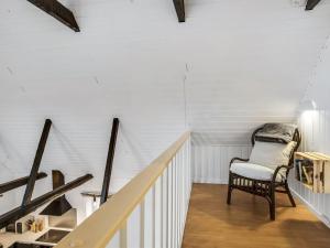 a white staircase with a chair in a room at Apartment Thorgot - 3km from the sea by Interhome in Pandrup
