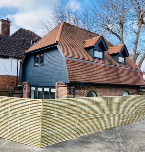 a wooden fence in front of a house at 2 bedroom cottage in Bromley suitable for 4 people in Bickley