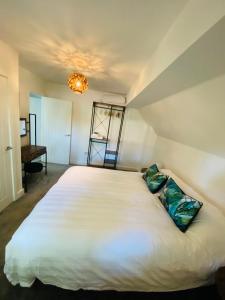 a bedroom with a large white bed with a chandelier at 2 bedroom cottage in Bromley suitable for 4 people in Bickley +2 photos