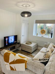 a living room with a couch and a tv at 2 bedroom cottage in Bromley suitable for 4 people in Bickley