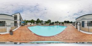 a large swimming pool at a resort with a building at Quality Inn Carthage in Carthage