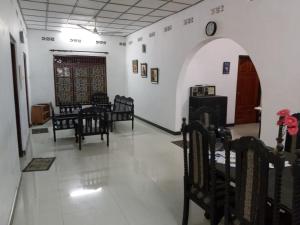a room with chairs and a wall with a clock at Trible R in Jaffna