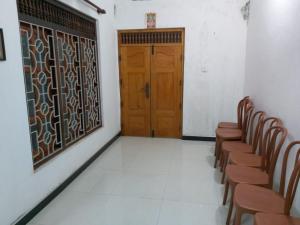 a room with chairs and a wooden door at Trible R in Jaffna