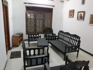 three chairs and a table in a room with a door at Trible R in Jaffna