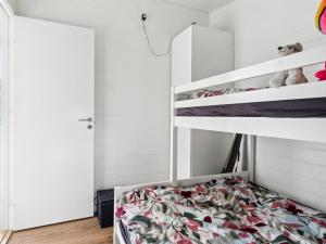 a childs bedroom with bunk beds and a closet at Holiday Home Rakita - 75m from the sea by Interhome in Tjørneholm