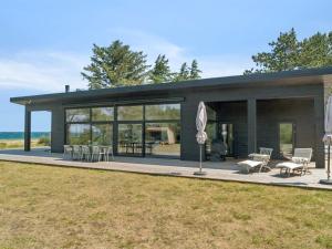 a house with glass doors and a patio at Holiday Home Rakita - 75m from the sea by Interhome in Tjørneholm