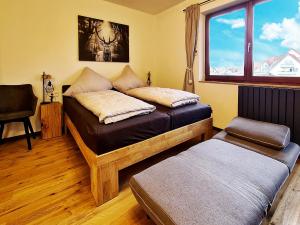 ラドルフツェル・アム・ボーデンゼーにあるSeemöwe - moderne Wohnung mit Balkonのベッドと椅子と窓のある寝室