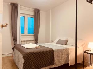 sypialnia z łóżkiem i oknem w obiekcie Apartamento El mirador de San Vicente w mieście San Vicente de la Sonsierra