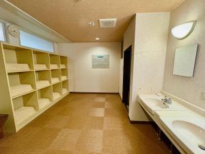 a large bathroom with two sinks and shelves at Hotel St. Malte in Hakuba +33 photos