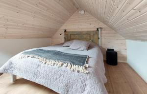 a bed in a room with a wooden ceiling at 1 Bedroom Beautiful Apartment In Vallåkra in Ekeby