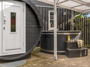 a wooden house with a plunge pool next to aitating at Holiday Home Neli - 850m to the fjord by Interhome in Storvorde