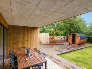 a wooden deck with a table and a tent at Holiday Home Liutulf - 350m to the fjord by Interhome in Skjern