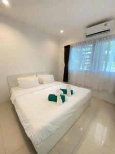 een slaapkamer met een bed met twee teddyberen erop bij Serene Hillside Hideaway in Ban Ko Khwan +31 foto's