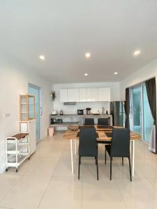 een keuken en eetkamer met een tafel en stoelen bij Serene Hillside Hideaway in Ban Ko Khwan