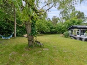 a park with a bench next to a tree at Holiday Home Nette - 100m from the sea by Interhome in Tjørneholm