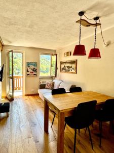 a living room with a wooden table and chairs at Nido Alpino - Vista Montagne e Relax Terme a 150m in Pré-Saint-Didier