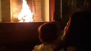a woman and a child sitting in front of a fireplace at Nivarta's Family Friendly Guesthouse in Aesch
