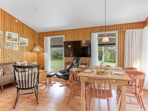 a dining room and living room with a table and chairs at Holiday Home Rikkart - 400m from the sea by Interhome in Dannemare