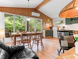 a kitchen and living room with a table and chairs at Holiday Home Rikkart - 400m from the sea by Interhome in Dannemare