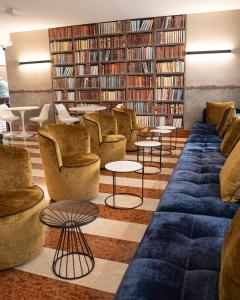a library with couches and tables and bookshelves at Hotel Giada Viale del Sole in Vicenza
