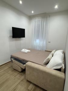a bedroom with a bed and a couch and a flat screen tv at Dimora Appia in Rome