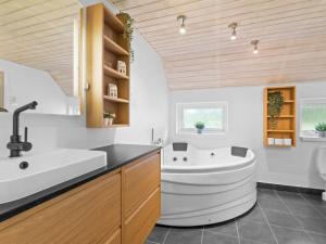 a bathroom with a white tub and a sink at Holiday Home Erle - 830m from the sea by Interhome in Nyby