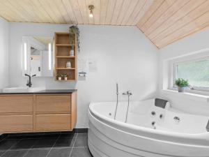 a bathroom with a large white tub and a sink at Holiday Home Erle - 830m from the sea by Interhome in Nyby