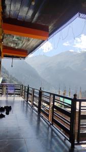 a balcony with a view of the mountains at Iris cafe and cozy stay in Tosh