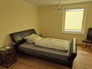 a bed in a room with a chair and a window at Werreufer 4ZKB 6 Einzelbetten in Detmold