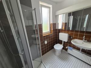 a bathroom with a toilet and a sink and a shower at Werreufer 3bed in Detmold