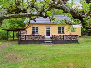 a yellow house with a fence in front of it at Holiday Home Andri - 1-5km from the sea by Interhome in Rønne