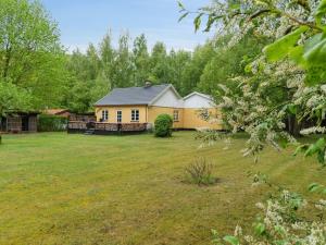 a yellow house in the middle of a yard at Holiday Home Andri - 1-5km from the sea by Interhome in Rønne